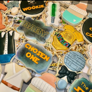 Set of Star Wars-themed baby shower sugar cookies featuring Baby Yoda, mini Stormtroopers, and cute lightsabers