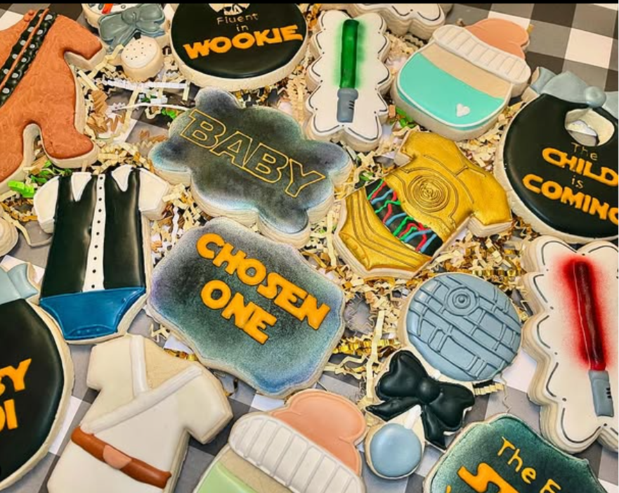 Set of Star Wars-themed baby shower sugar cookies featuring Baby Yoda, mini Stormtroopers, and cute lightsabers